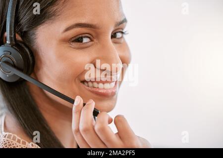 Seguire le istruzioni e risolvere bene questo problema. Ritratto ritagliato di una giovane e attraente operatore di call center che indossa una cuffia mentre lavora Foto Stock