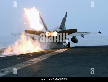 Con un lampo di fuoco causato dal carburante incombusto, un aereo US Marine Corps (USMC) F/A-18C Hornet assegnato a Marine Fighter Attack Squadron due tre (VMFA-232) lancia dal ponte di volo a bordo della classe Nimitz: Aircraft Carrier, USS ABRAHAM LINCOLN (CVN 72), in qualità di aeromobile assegnato alla Carrier Air Wing Two (CVW-2), conduce le operazioni in preparazione di un prossimo spiegamento. Base: USS Abraham Lincoln (CVN 72) Nazione: Oceano Pacifico (POC) Foto Stock