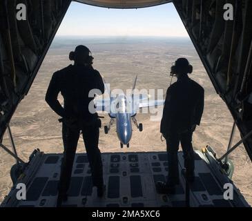 050311-N-1539M-001. [Completa] Scene Caption: US Marine Corps (USMC) STAFF Sergente (SSGT) Donnie Morris e Sergente (SGT) Baron Morales, stand a bordo della USMC C-130 Hercules missione di supporto aereo, 'Fat Albert,' per la US Navy (USN) Aerial Demonstration Team i 'Blue Angles,' come tenente USN (LT) John Allison, Manovra il suo F/A-18A Hornet in posizione di percorso dietro l'aereo, per una missione fotografica sul paesaggio desertico della Imperial Valley vicino a El Centro, California (CA). I Blue Angels stanno completando il loro intenso programma di allenamento invernale a bordo della Naval Air fa Foto Stock