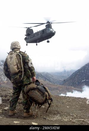 US Marine Corps (USMC) First Sergeant (1SGT) Vincent Santiago, assegnato a Kilo Company, 3rd Battaglione, 3rd Marine Regiment, attende come un US Army (USA) CH-47 Chinook elicottero si avvicina a un sito di zona di atterraggio situato nelle vicinanze montuose di Methar Lam, Afghanistan, durante l'operazione Mavericks, Dove i Marines dell'USMC hanno assegnato 3rd battaglione, 3rd Marines stanno conducendo le operazioni di sicurezza e stabilizzazione (SASO) a sostegno dell'operazione CHE SOPPORTA LA LIBERTÀ. Soggetto operativo/Serie: LIBERTÀ DUREVOLE base: Methar Lam Paese: Afghanistan (AFG) Foto Stock