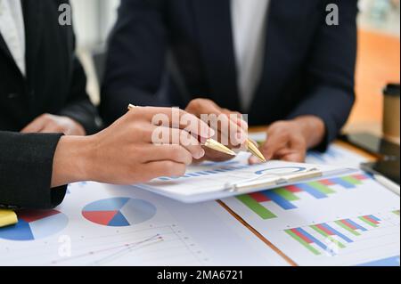 Immagine ritagliata, il team di analisti finanziari professionisti che si occupa di brainstorming sul proprio progetto finanziario, analisi del grafico dei dati di vendita, revisione del piano finanziario Foto Stock