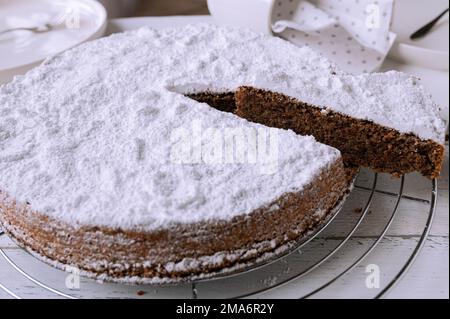Succosa torta di mandorle al cioccolato su una griglia rinfrescante. Tradizionale torta caprese italiana su sfondo bianco Foto Stock