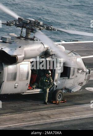 A sostegno delle operazioni di soccorso dell'uragano Katrina, uno SPECIALISTA di Aviation Warfare della Marina statunitense (USN) assegnato a Helicopter Sea Combat Squadron 29 (HELSEACOMBATRON TWENTY NINE) attende mentre il suo elicottero SH-60 Seahawk prende le forniture sul ponte di volo della USS HARRY S. TRUMAN (CVN 75), nel Golfo del Messico. (Immagine duplicata, vedere anche DNSD0602428 o cercare 050905N6495K041). Base: USS Harry S. Truman (CVN 75) Paese: Golfo del Messico Foto Stock