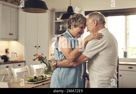 Danziamo ancora in cucina dopo tutti questi anni. una coppia anziana che balla in cucina a casa. Foto Stock