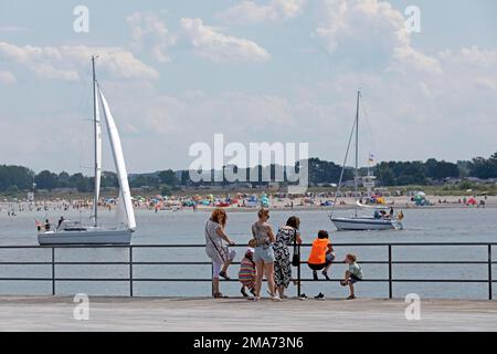 Famiglia guardando attraverso il fiume trave alla spiaggia di Primall, barche a vela, Travemuende, Lubecca, Schleswig-Holstein, Germania Foto Stock