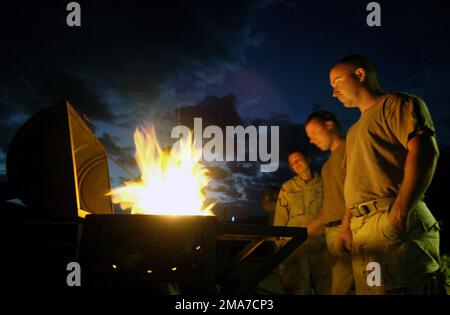 051120-F-7234P-143. [Complete] Scene Caption: US Navy (USN) PETTY Officer terza Classe (PO3) Jessica Young (a sinistra), PO3 Arthur Perry, e PETTY Officer seconda Classe (PO2) Ron Brown (a destra) stare sopra una griglia di fortuna durante il tempo di inattività in un campo militare degli Stati Uniti ad Harar, Etiopia. USN costruzione battaglione (SEABEE) con Naval Mobile costruzione battaglione 3 (NMCB 3), Port Hueneme, California (CA), scavato tre pozzi e sono messa in scena per perforare diversi pozzi a pompa manuale, per fornire migliaia di etiopi e il loro bestiame con acqua potabile. Soldati dell'esercito DEGLI STATI UNITI (USA) da 1st battaglione (BN), 294th fanteria di Foto Stock