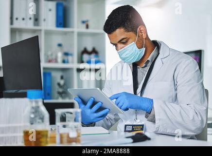 Fai le domande giuste e otterrai le risposte giuste. un giovane ricercatore maschile che lavora in un laboratorio. Foto Stock