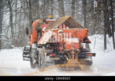 In inverno un camion stendente sparge sabbia su una strada urbana: Russia - Febbraio 2021 Foto Stock