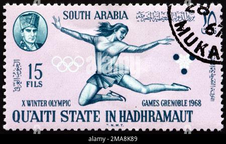 YEMEN DEL SUD - CIRCA 1967: Un francobollo stampato nello Stato del Quaiti del Sud dello Yemen in Hadhramaut mostra il pattinaggio di figura, 1968 Grenoble, circa 1967 Foto Stock