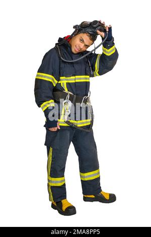 Pompiere in uniforme e con respiratore d'aria toglie la maschera protettiva Foto Stock