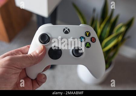 LONDRA - 06 GENNAIO 2023: Uomo che gioca a Xbox Series S controller bianco nel soggiorno moderno Foto Stock