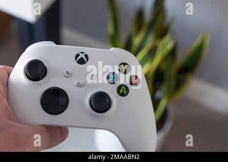 LONDRA - 16 GENNAIO 2023: Uomo che gioca a Xbox Series S controller bianco nel soggiorno moderno Foto Stock