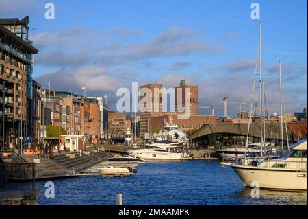 Aker Brygge con la marina e il municipio sullo sfondo, Oslo, Norvegia. Foto Stock
