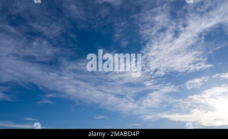 Raggi di sole tra nuvole bianche in cielo blu. cielo sfondo Foto Stock