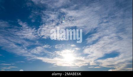 Raggi di sole tra nuvole bianche in cielo blu. cielo sfondo Foto Stock