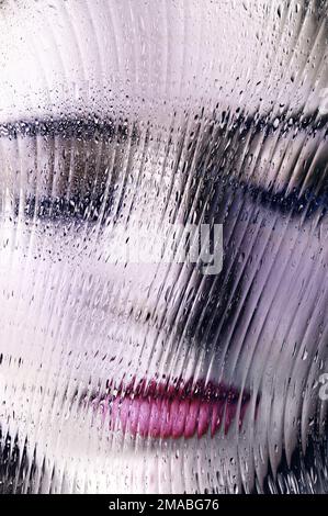 faccia giovane donna con occhi chiusi, con un effetto specchio sfaccettato Foto Stock