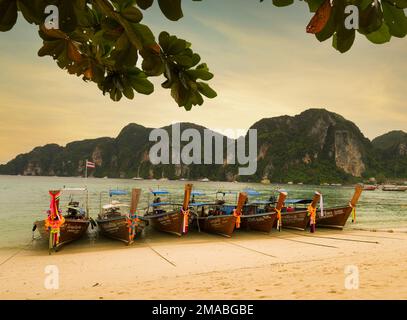 Phi Phi Island, Krabi, Thailandia. Dicembre 3, 2022. La famosa spiaggia di Ton Sai al tramonto. Barche tradizionali sulla spiaggia e splendida vista sulla baia Foto Stock