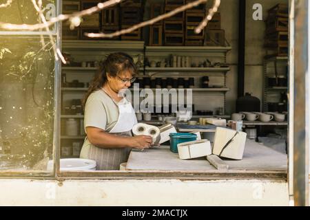 Master vasaio che lavora nel suo studio. Il processo di creazione di ceramica. Foto Stock