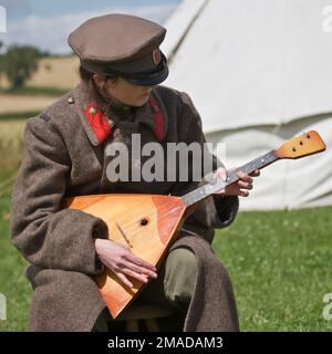 Un soldato dell'Esercito Imperiale Russo gioca una balalaika di stile tradizionale Foto Stock