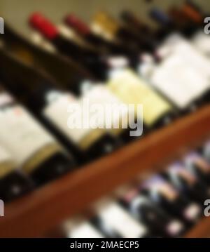 Bottiglie di champagne con portabagagli sfocate su scaffali di legno Foto Stock