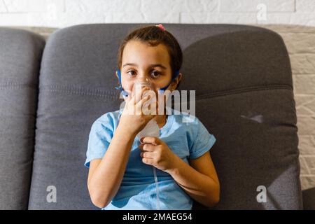 Ragazza carina con maschera nebulizzatore. Foto Stock