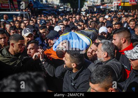 Jenin, Medio Oriente. 19th Jan, 2023. (NOTA DEL REDATTORE: Immagine raffigura la morte)gli uomini d'arma e i lutti palestinesi portano il corpo di un palestinese, uno dei due palestinesi, Adham Jabareen, 28 anni, e Jawad Bawaqneh, 57 anni, Che sono stati uccisi dai proiettili dell'esercito israeliano durante un raid nel campo profughi di Jenin, durante i loro funerali nella città di Jenin, nella Cisgiordania occupata. Testimoni oculari hanno detto che Jabareen è stato ucciso a colpi di arma da fuoco dall'esercito israeliano, e l'insegnante di scuola Bawaqnah ha cercato di fornirgli il primo soccorso dopo che è caduto a terra. Durante il suo tentativo di aiutarlo, un è Foto Stock