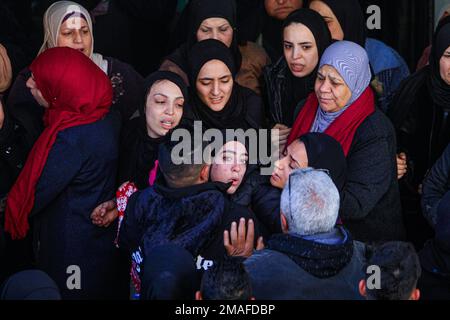 Jenin, Medio Oriente. 19th Jan, 2023. I parenti piangono durante la cerimonia funeraria dei due palestinesi, Adham Jabareen, 28 anni, e Jawad Bawaqneh, 57 anni, Che sono stati uccisi dalle pallottole dell'esercito israeliano durante un raid nel campo profughi di Jenin nella Cisgiordania occupata. Testimoni oculari hanno detto che Jabareen è stato ucciso a colpi di arma da fuoco dall'esercito israeliano, e l'insegnante di scuola Bawaqnah ha cercato di fornirgli il primo soccorso dopo che è caduto a terra. Durante il suo tentativo di aiutarlo, un cecchino israeliano lo ha sparato, e dopo di che le forze israeliane hanno impedito ambulanze e personale medico Foto Stock