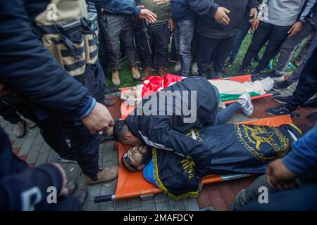 Jenin, Medio Oriente. 19th Jan, 2023. (NOTA DELL'EDITORE: Immagine raffigura la morte) i parenti si salutano e piangono accanto ai corpi dei due palestinesi, Adham Jabareen, 28 anni, e Jawad Bawaqneh, 57 anni, Che sono stati uccisi dalle pallottole dell'esercito israeliano durante un raid nel campo profughi di Jenin nella Cisgiordania occupata. Testimoni oculari hanno detto che Jabareen è stato ucciso a colpi di arma da fuoco dall'esercito israeliano, e l'insegnante di scuola Bawaqnah ha cercato di fornirgli il primo soccorso dopo che è caduto a terra. Durante il suo tentativo di aiutarlo, un cecchino israeliano lo sparò, e dopo di che le forze israeliane prepresero Foto Stock