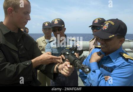 060521-N-9851B-005. [Complete] Scene Caption: US Navy (USN) ENSIGN (ESN) Spencer Seufort (a sinistra), un membro del team Visit, Board, Search and Sequesture (VBSS) a bordo della USN Arleigh Burke Class (Flight II) Guided Missile Destroyer (Aegis), USS HOPPER (DDG 70), familiarizza gli ufficiali di collegamento delle navi della Malesia, Thailandia, Thailandia, Thailandia, Thailandia Indonesia e Filippine con la carbina M4A1 da 5,56 mm. L'USS HOPPER ospita ufficiali di collegamento in visita mentre conduce le operazioni nel Mare delle Filippine mentre partecipa alle esercitazioni di cooperazione contro il terrorismo (SEACAT) dell'Asia sudorientale. SEACAT è una settimana Foto Stock