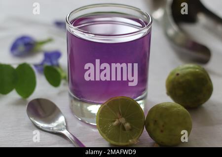 Tè di fiori di piselli di farfalla di colore rosa. Il tè blu di fiore di pisello della farfalla cambia colore a rosa quando il succo di limone è aggiunto. Il cambiamento acido di calce Foto Stock