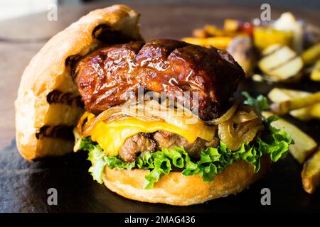 Autentico hamburger americano di prima qualità con una tenera costoletta di maiale. Foto Stock