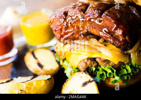 Autentico hamburger americano di prima qualità con una tenera costoletta di maiale. Foto Stock