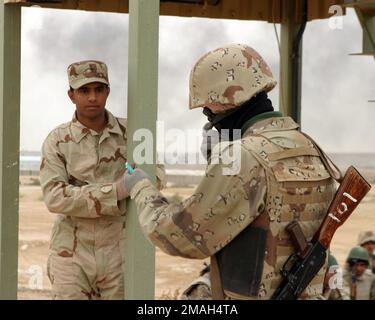 070324-M-2166H-025. [Complete] Scene Caption: An Iraqi Army Soldier in the School of Infantry (SOI) ispeziona un documento d'identità e chiama le informazioni al suo istruttore su una radio immaginaria durante un esercizio di pratica a Camp Yasser sulla base aerea di al Asad, Iraq il 24 marzo 2007. SOI è una scuola di formazione di dieci giorni che insegna tecniche di combattimento avanzate e tattiche ai nuovi soldati dell'esercito iracheno prima che riferiscano ai loro battaglioni. 2nd Battaglione 7th Divisione Armata irachena il Team militare di transizione è schierato come parte di MNF-W a sostegno dell'operazione irachena libertà nella provincia di Anbar in Iraq per svilupparsi Foto Stock