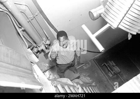 Yeoman 3rd Class Burch, l'uomo di fondo per una delle pistole Mark 7 16-inch/50-calibro nella torretta n. 3 a bordo della nave da guerra USS IOWA (BB-61), segnala la sua disponibilità mentre si trova nella sua stazione sotto la breccia della pistola. Paese: Sconosciuto Foto Stock