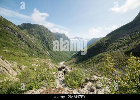 Escursioni sul sentiero per il ghiacciaio di Buarbreen a Buardalen, vicino a Odda, Norvegia, in una giornata di sole estate. Alcuni escursionisti nella foto. Foto Stock