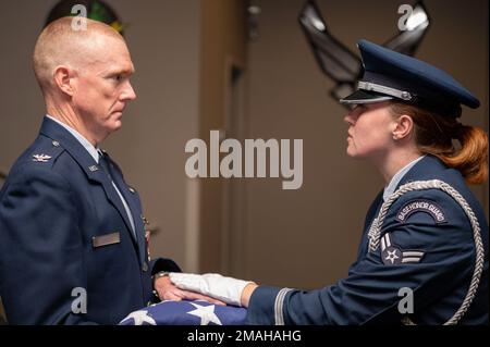 NEGLI STATI UNITI Air Force Ceremonial Guardswoman presenta la bandiera americana agli Stati Uniti Air Force col. John Dorsch, 24th Special Operations Wing Surgeon General durante la sua cerimonia di pensionamento, 26 maggio 2022 a Hurlburt Field, Fla. La Guardia d'onore è responsabile del supporto di eventi speciali come memoriali, cambi di comando, ritiri militari, banchetti di premiazione e vari eventi civici. Foto Stock