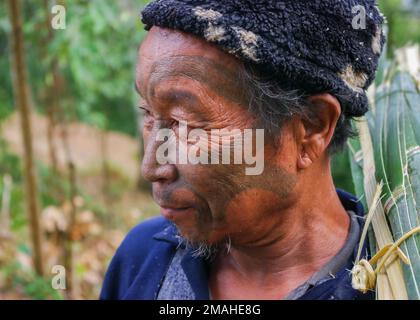 Mon District, Nagaland, India - 03 02 2009 : Ritratto esterno della vecchia tribù Naga Konyak cacciatore guerriero testa con tatuaggio facciale tradizionale Foto Stock