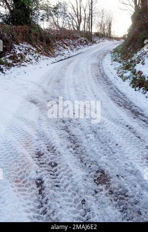 Ghiaccio e neve ghiacciata sulla strada rurale corsia di campagna in inverno gennaio 2023 Carmarthenshire Galles Regno Unito Gran Bretagna KATHY DEWITT Foto Stock