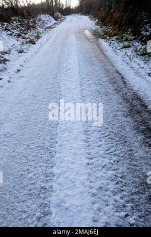 Ghiaccio e neve ghiacciata sulla strada rurale corsia di campagna in inverno gennaio 2023 Carmarthenshire Galles Regno Unito Gran Bretagna KATHY DEWITT Foto Stock