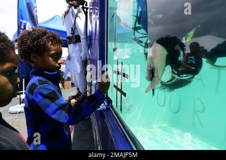 San Pedro, California (28 maggio 2022) – Jayden Crenshaw, di sette anni, di Los Angeles, gioca a tic-tac-toe con un subacqueo della Marina al Main Expo Footprint vicino al museo della nave da guerra USS Iowa come parte della Los Angeles Fleet Week (LAFW) 28 maggio 2022. Il LAFW è un'opportunità per il pubblico americano di incontrare le squadre della Marina, del corpo dei Marine e della Guardia Costiera e di sperimentare i servizi marini americani. Durante la settimana della flotta, i membri del servizio partecipano a vari eventi di servizio della comunità, espongono le capacità e le attrezzature alla comunità e godono dell'ospitalità di Los Angeles e delle sue aree circostanti. Foto Stock