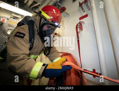 220528-N-DE439-1060 NORWEGIAN SEA (28 maggio 2022) Hull Maintenance Technician Fireman Zander Martinez, di Houston, Texas, prepara una manichetta durante un'esercitazione antincendio di classe alpha a bordo del cacciatorpediniere missilistico guidato di classe Arleigh Burke USS Porter (DDG 78), 28 maggio 2022. Porter è in fase di distribuzione pianificata negli Stati Uniti Naval Forces Europe area of Operations, impiegato dagli Stati Uniti Sesta flotta per difendere gli interessi degli Stati Uniti, degli alleati e dei partner. Foto Stock