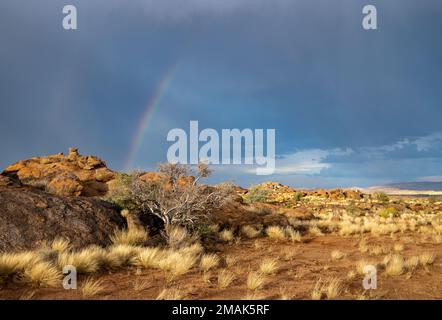 Arcobaleno su uno sperone roccioso in tempesta. Parco Nazionale delle Cascate di Augrabies. Capo Settentrionale, Sudafrica. Foto Stock