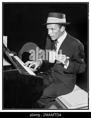 Frank Sinatra suona il pianoforte con una mano, tenendo una piccola tazza di carta nell'altra, in una foto pubblicitaria della NBC del 1954, Hollywood USA Foto Stock