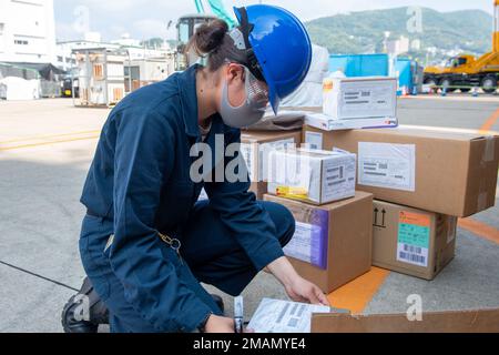 SASEBO, Giappone (31 maggio 2022), Airman Marcela Echeverry, dalla Colombia, assegnato alla nave d'assalto anfibio schierata in avanti USS America (LHA 6), smista la posta sul molo. L'America, nave guida dell'America Amphibious Ready Group, sta operando nell'area di responsabilità della 7th Fleet degli Stati Uniti per migliorare l'interoperabilità con alleati e partner e servire come forza di risposta pronta per difendere la pace e la stabilità nella regione Indo-Pacifico. Operazioni giornaliere, ForgedByTheSea, USS America (LHA 6), Foto Stock