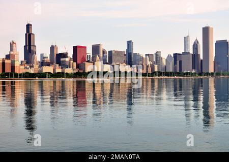 Chicago, Illinois, Stati Uniti. Una mattina di tarda primavera vago si riflette nel Lago Michigan insieme agli edifici che compongono lo skyline di Chicago. Foto Stock