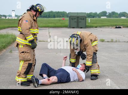 I vigili del fuoco assistono una vittima volontaria in un sito di collisione simulato durante un esercizio di risposta agli incidenti rilevanti (MARE) presso la base della Guardia Nazionale aerea Selfridge, Michigan, 1 giugno 2022. Durante il MARE, i soccorritori reagiscono rapidamente a un incidente aereo simulato. L'esercizio è stato progettato per testare la capacità del soccorritore Selfridge Air National Guard base di collaborare, valutare e valutare il piano di risposta alle emergenze dell'impianto militare e l'efficacia dei soccorritori locali. Foto Stock