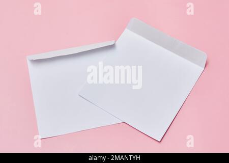 due buste bianche su sfondo rosa con spazio di copia per il testo o il messaggio, vista dall'alto foto di scorta Foto Stock