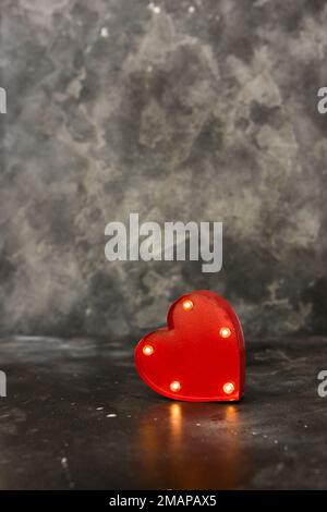 Cuore illuminato rosso su un bacground nero. Spazio di copia Foto Stock