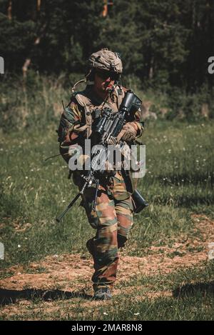 Un soldato delle forze armate belghe assegnato all'ISTAR COY reagisce al contatto che porta una mitragliatrice leggera da M249 mm durante l'esercizio Combined Resolve 17 (CBR 17) presso il Joint Multinational Readiness Center di Hohenfels, in Germania, il 3 giugno 2022. CBR 17 è un ente statunitense L'esercizio militare, composto da 5.600 membri del servizio, alleati della NATO e partner di oltre 10 paesi, è stato progettato per valutare le capacità delle unità di condurre operazioni in uno spazio di battaglia multidominio. Foto Stock