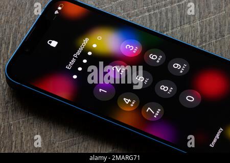 Vengono visualizzate cinque cifre immesse, con una sola cifra a sinistra, su un iPhone bloccato con codice di accesso. Tenta di sbloccare un iPhone. Foto Stock